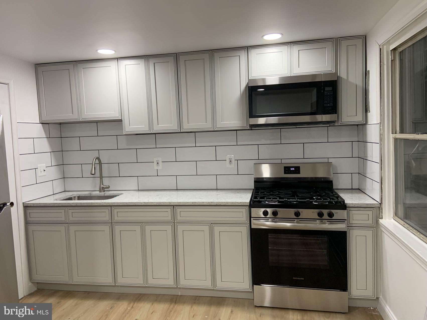 a kitchen with stainless steel appliances granite countertop a stove and a microwave