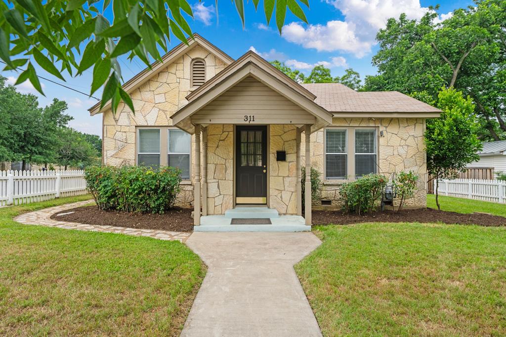 a front view of a house with a garden