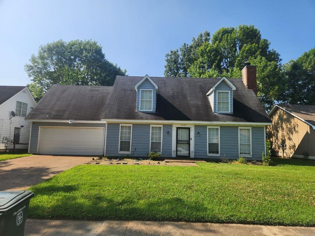 a front view of house with yard and green space