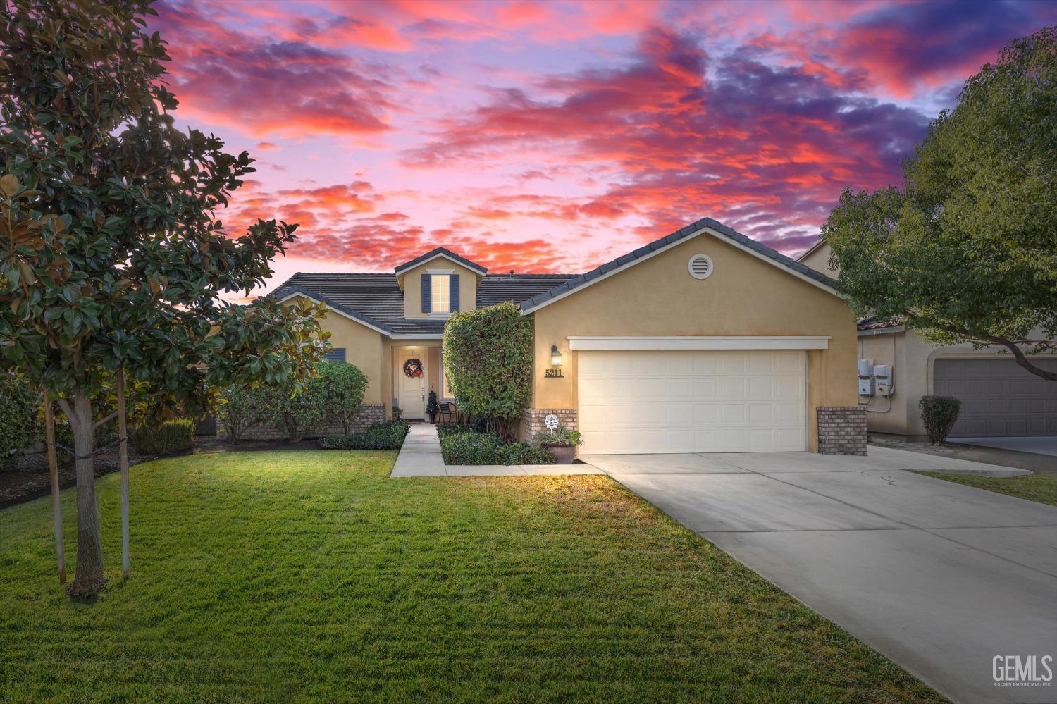 a front view of a house with yard and green space