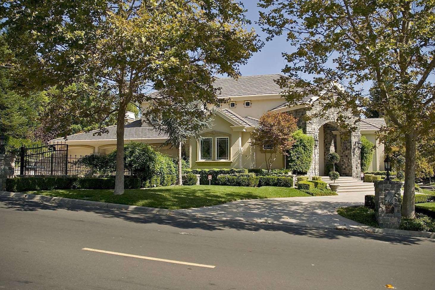 a front view of a house with a yard and trees