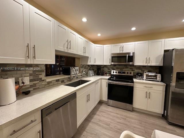 a kitchen with kitchen island granite countertop a sink a counter top space stainless steel appliances and cabinets