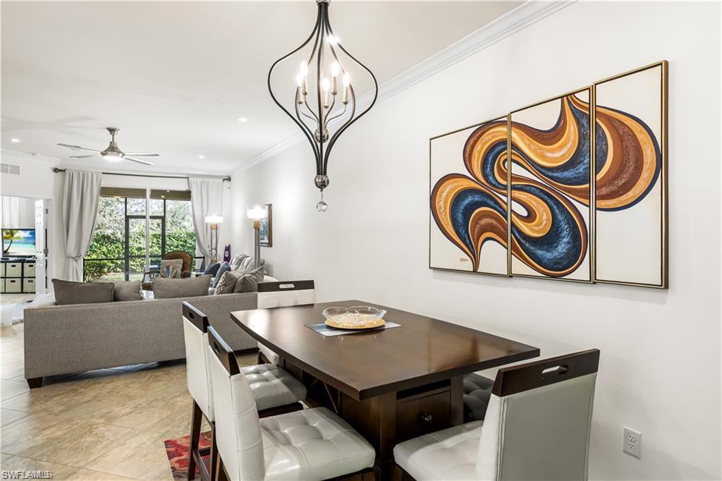 Dining room featuring crown molding and ceiling fan with notable chandelier