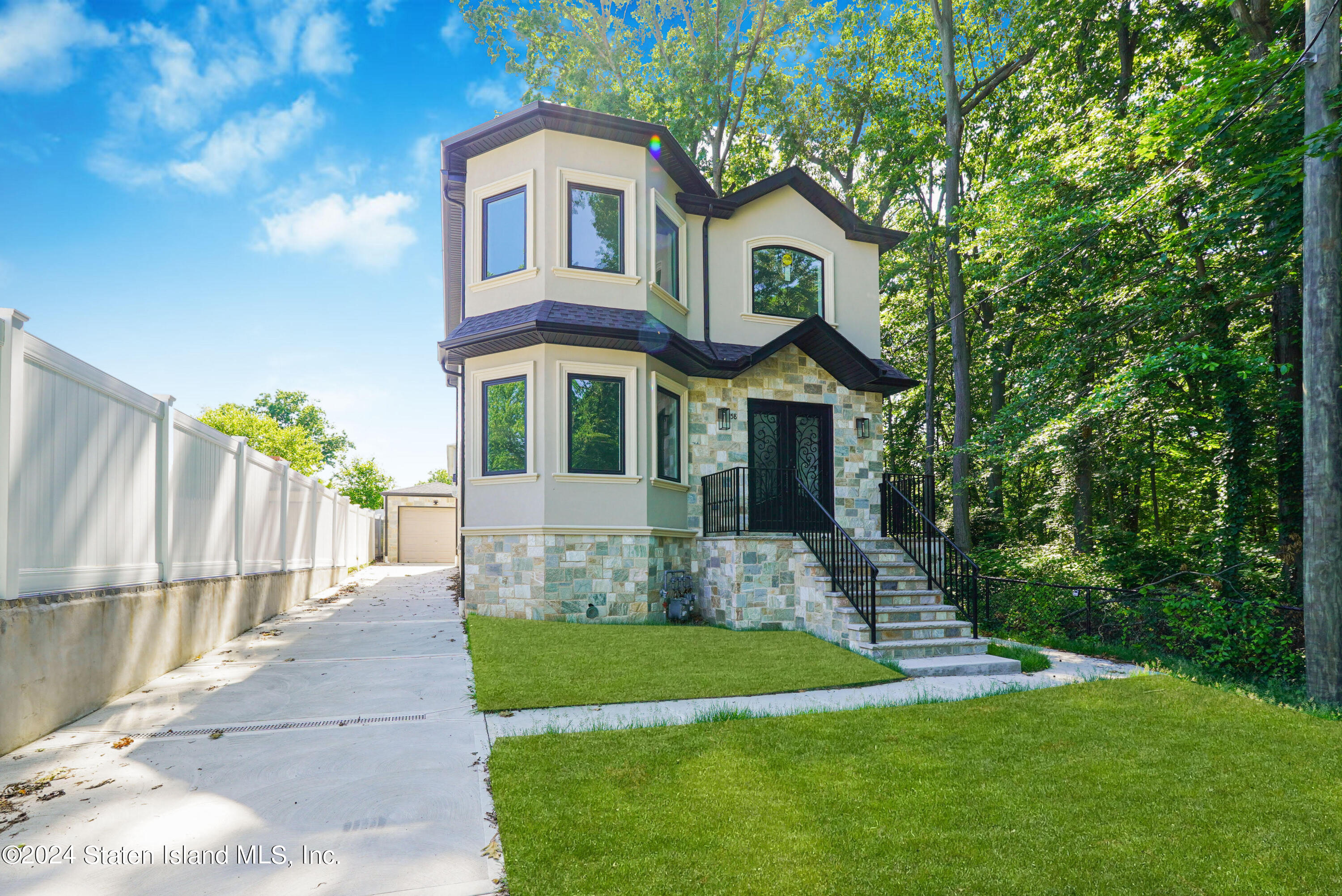 a front view of a house with a yard garden and outdoor seating