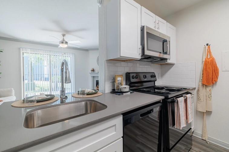 a kitchen with stainless steel appliances granite countertop a sink stove and cabinets