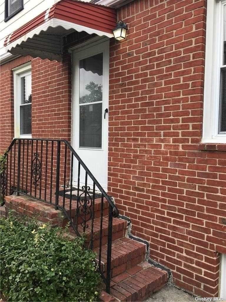 a view of a brick house with stairs and a floor to ceiling window