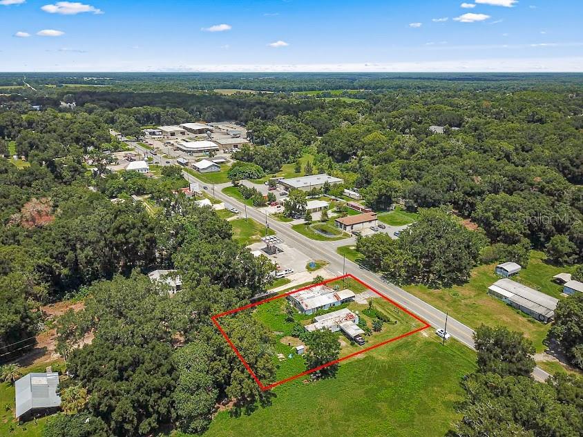 an aerial view of residential houses with outdoor space and trees