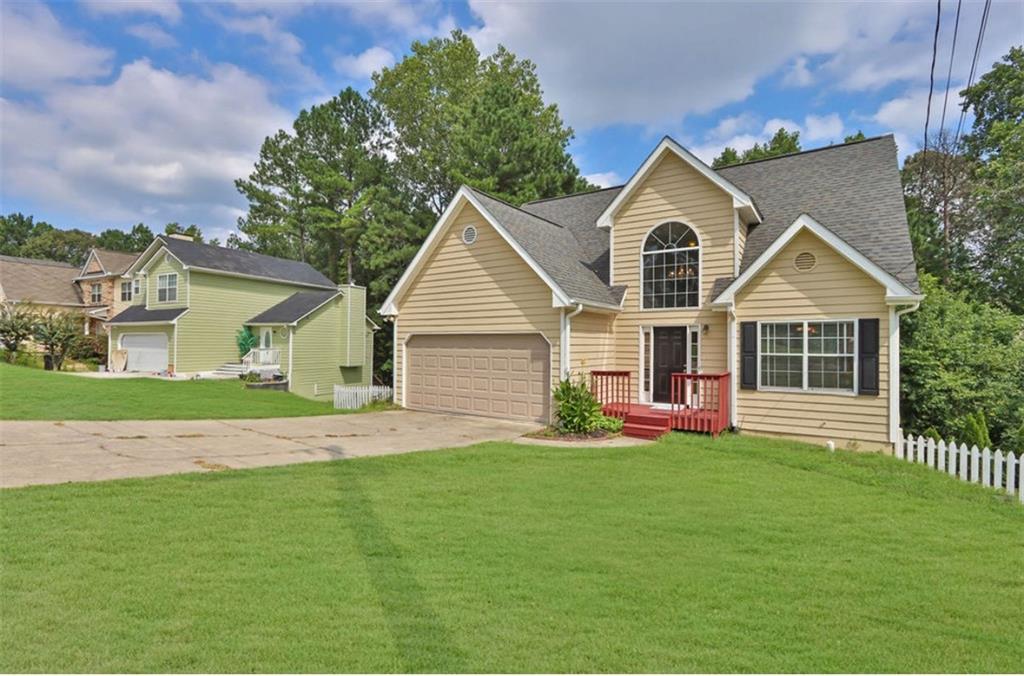 a front view of a house with a garden and yard