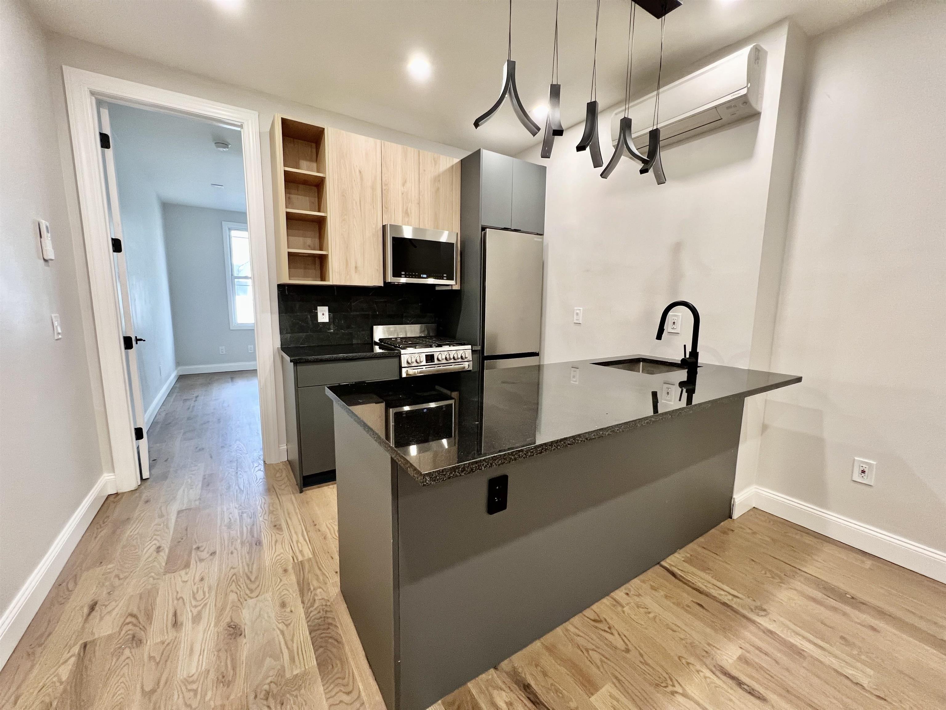 a kitchen with stainless steel appliances a refrigerator a sink and white cabinets