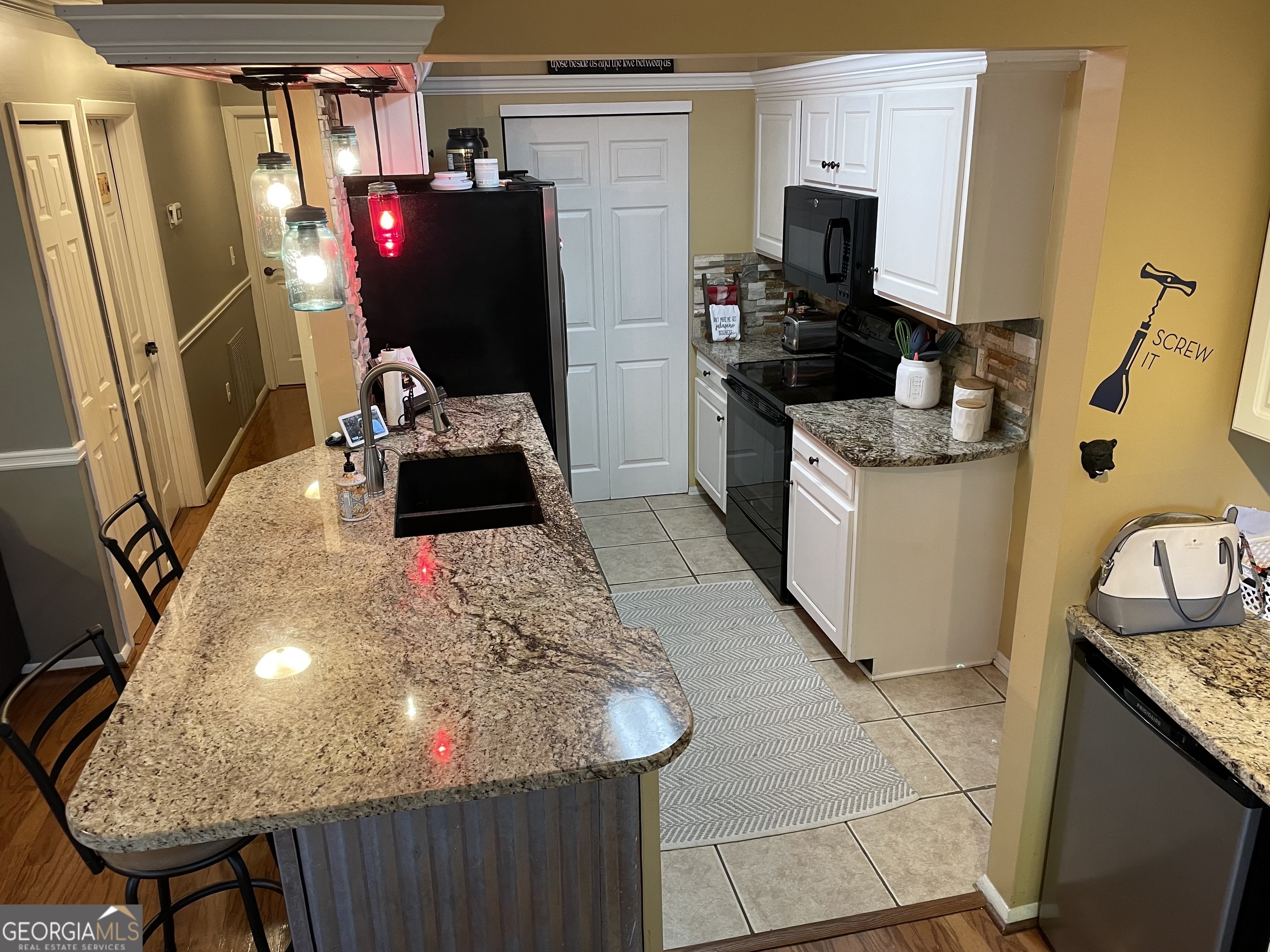 a kitchen with granite countertop a sink stove and refrigerator