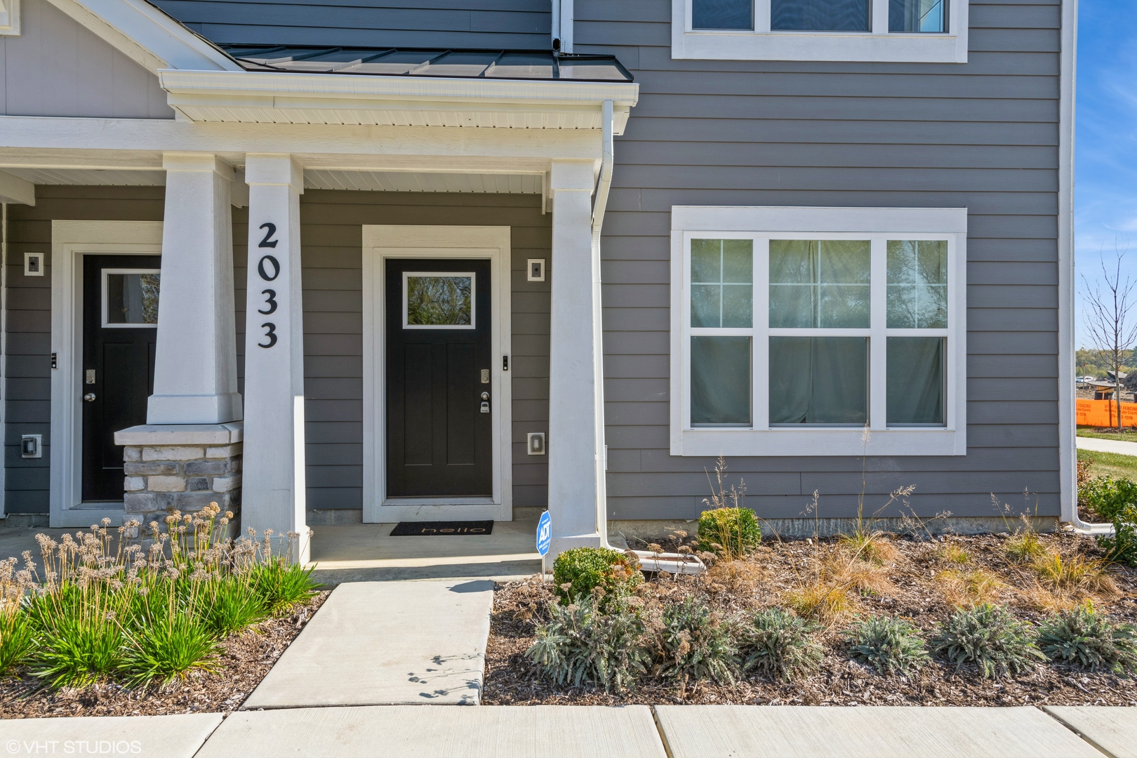 front view of a brick house with potted plants