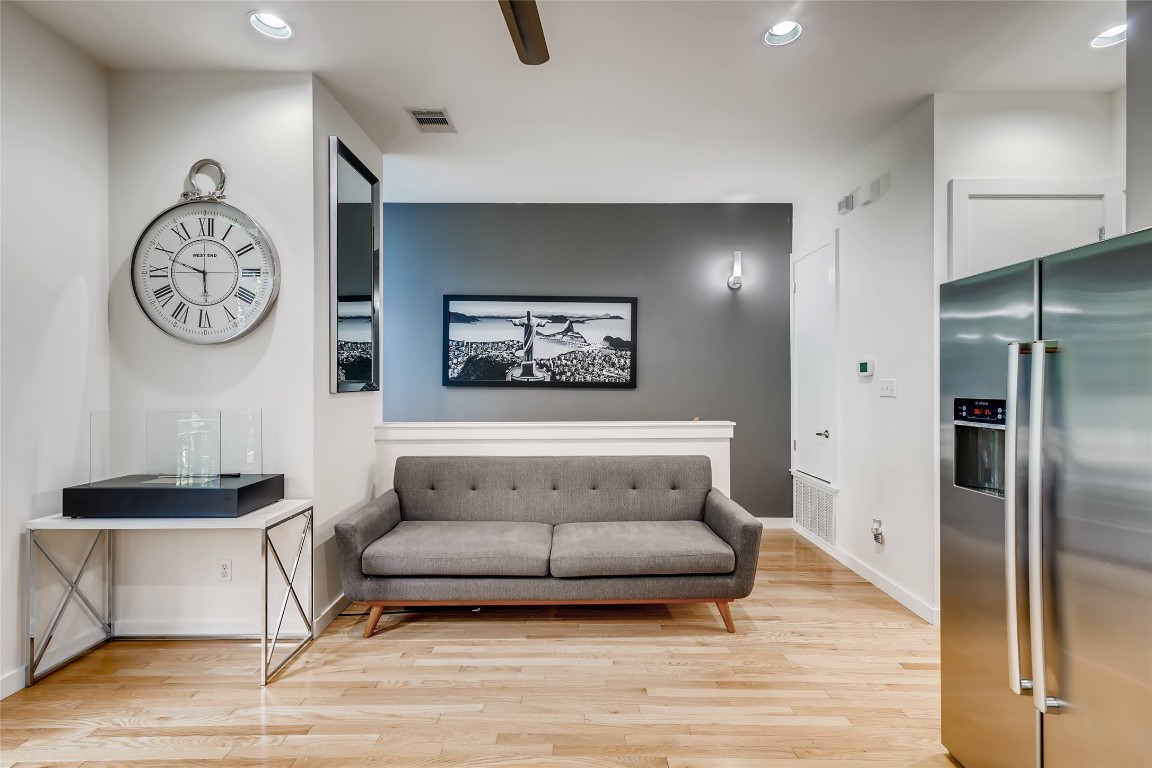 a living room with furniture a clock and a view of bathroom