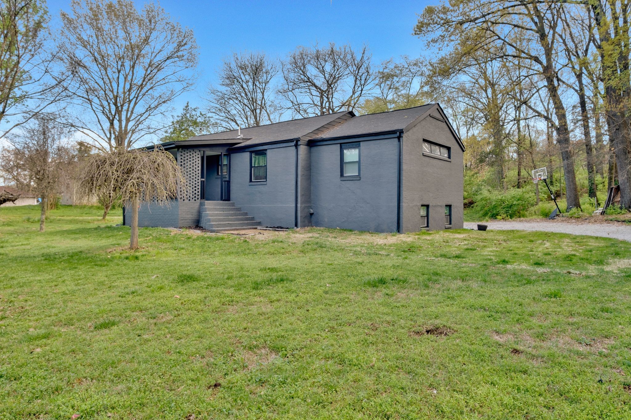 a front view of house with yard and tree in it