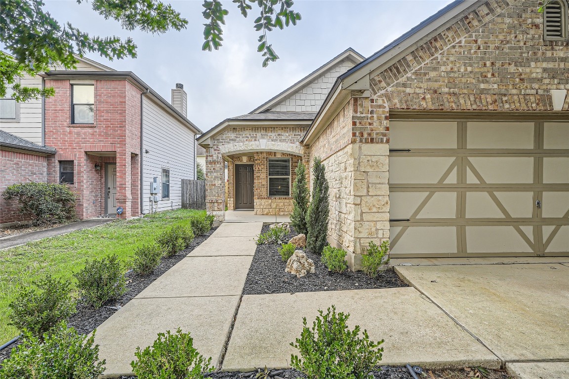 a front view of a house with a yard and potted plants