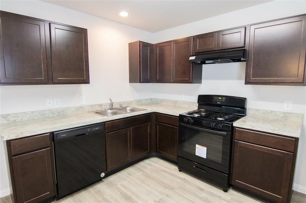 a kitchen with stainless steel appliances granite countertop a sink and a stove