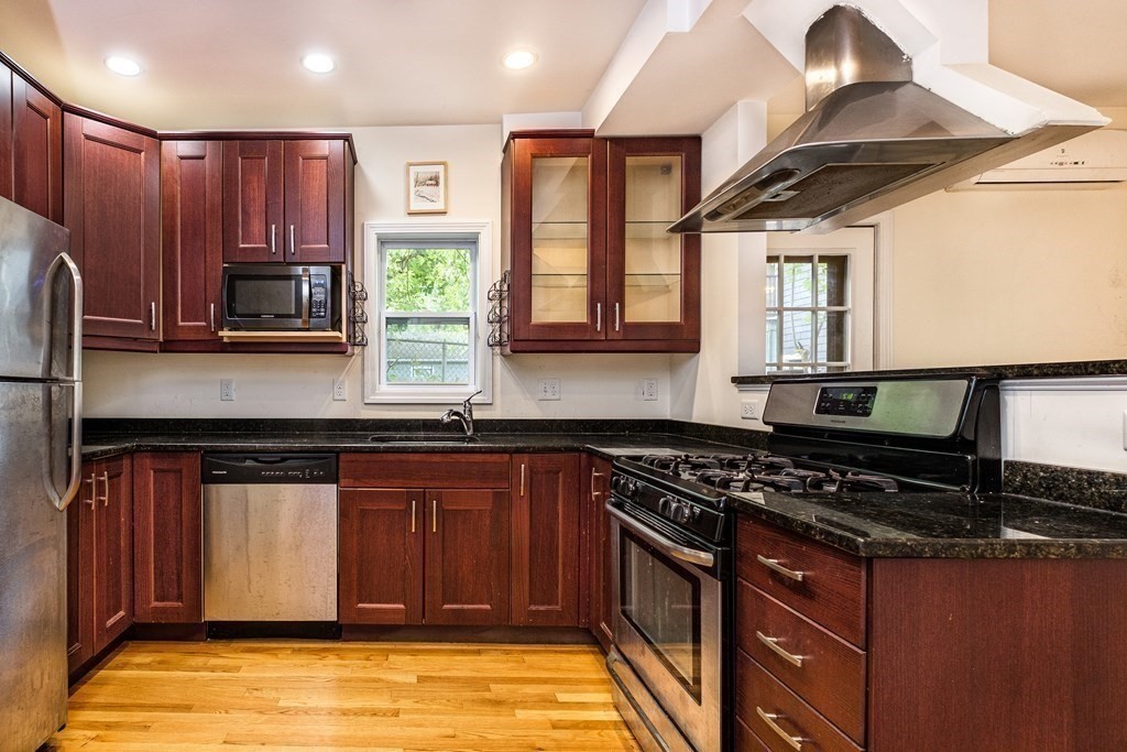 a kitchen with stainless steel appliances granite countertop a stove a sink and a microwave