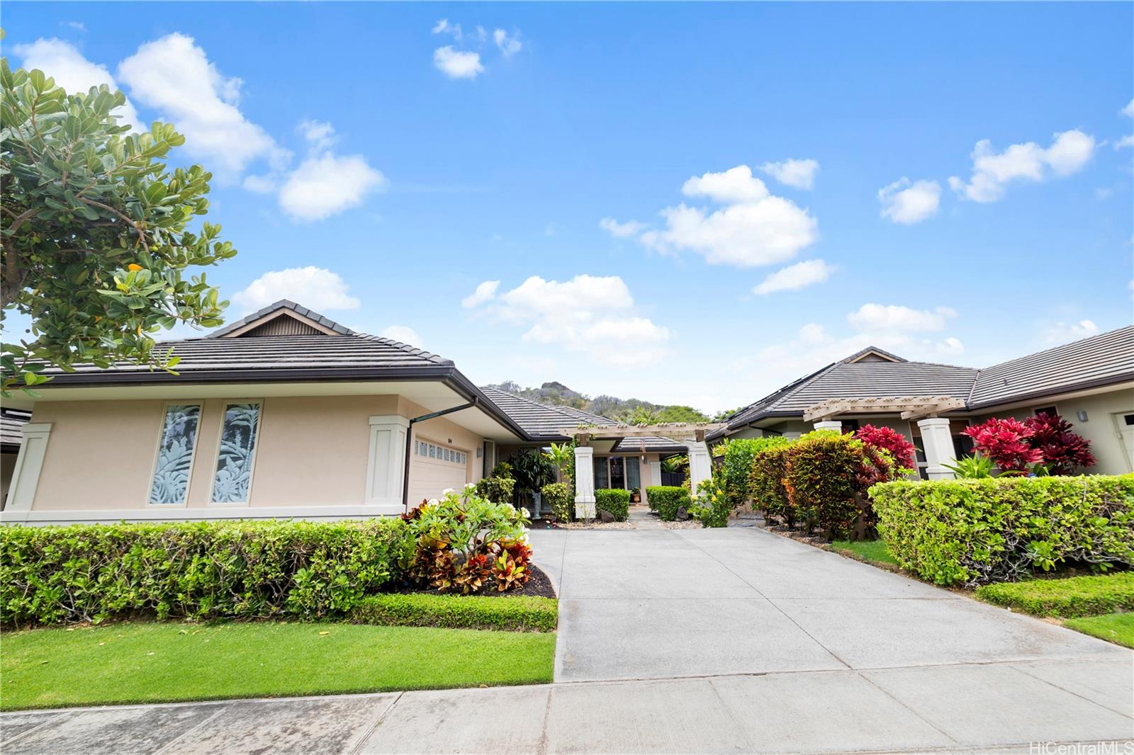 a front view of a house with a yard and potted plants