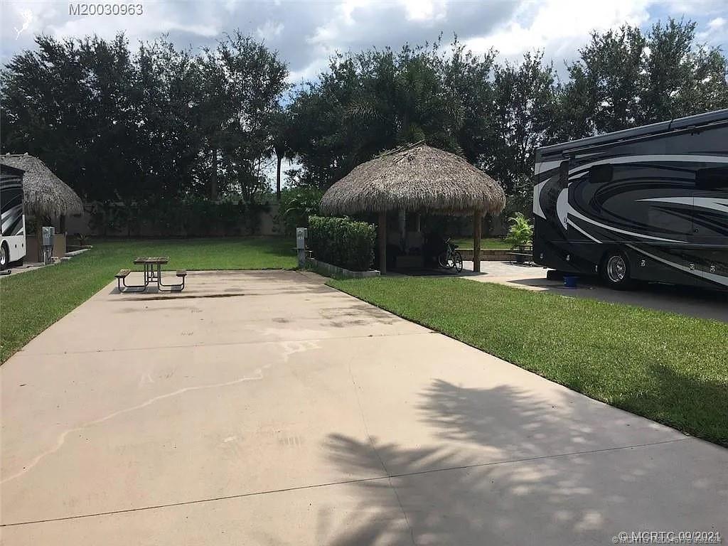 a backyard of a house with barbeque oven and trees