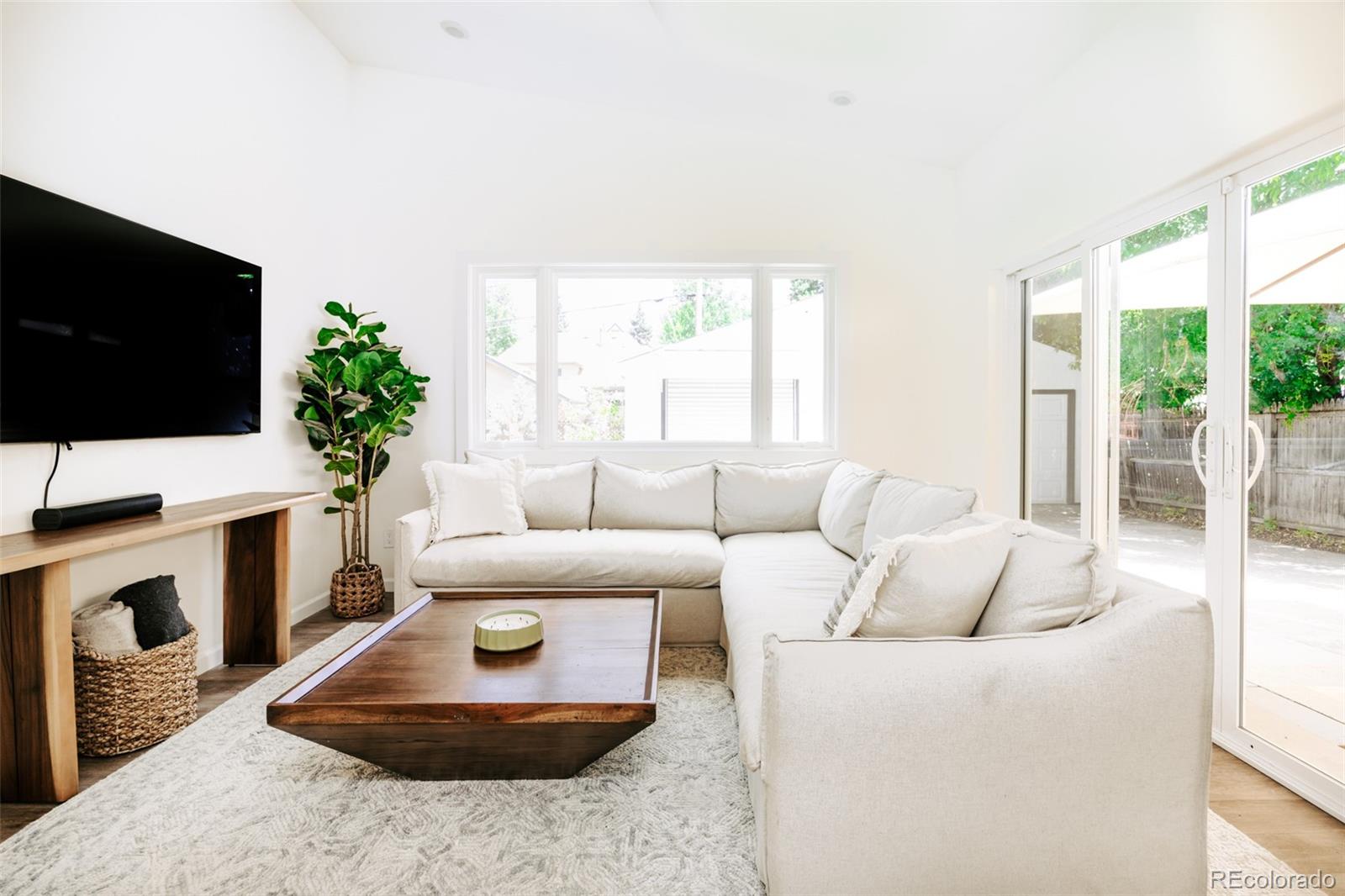 a living room with furniture a flat screen tv and a fireplace