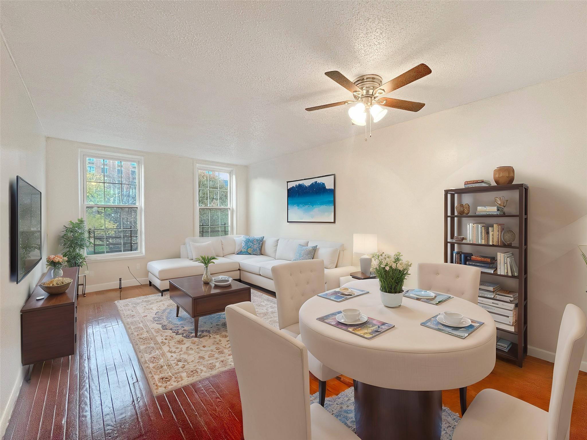 Dining room with ceiling fan, wood-type flooring, and a textured ceiling