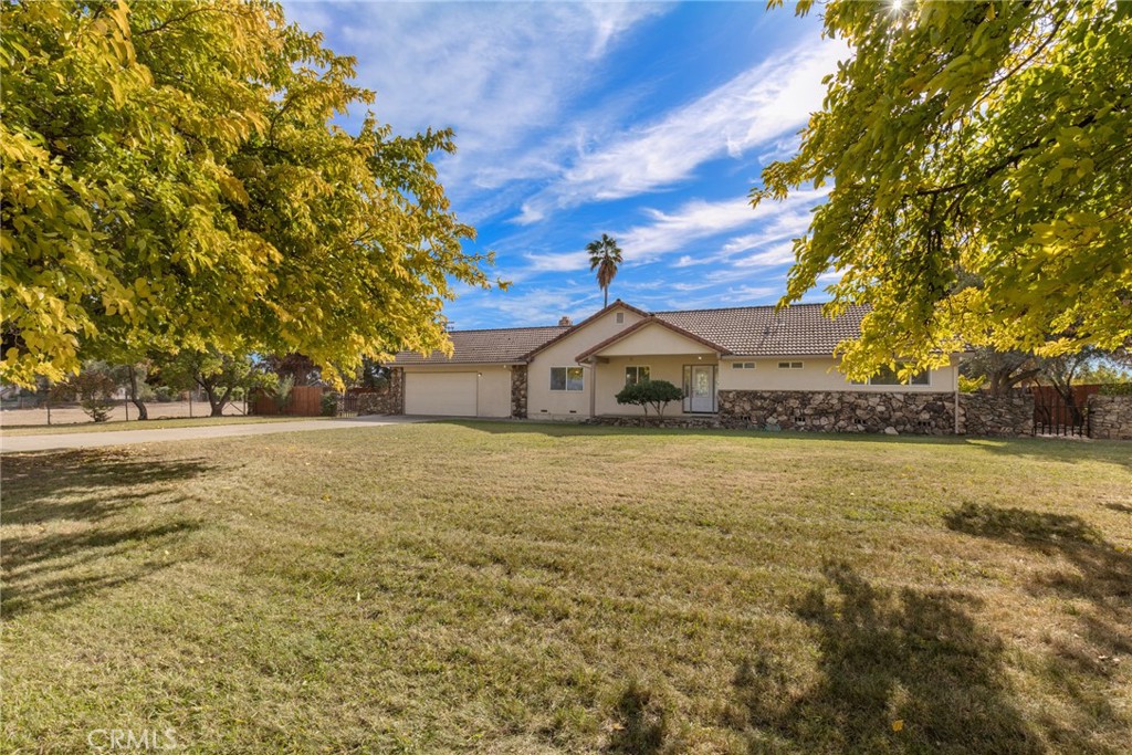 a front view of house with yard and trees around