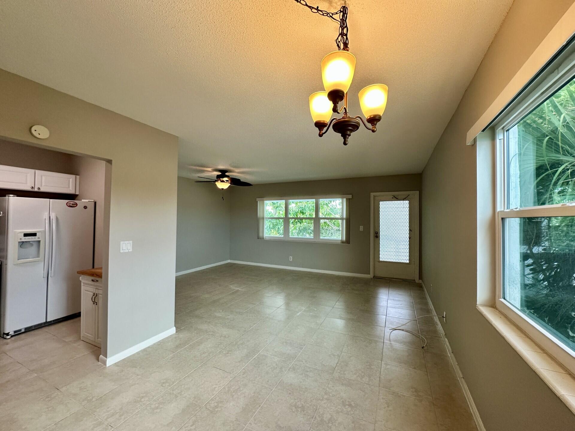 an empty room with windows and ceiling fan