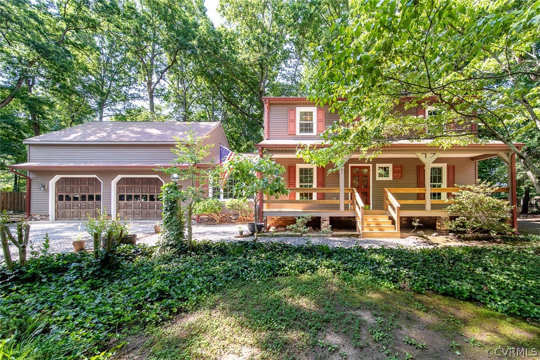 a front view of a house with garden and trees