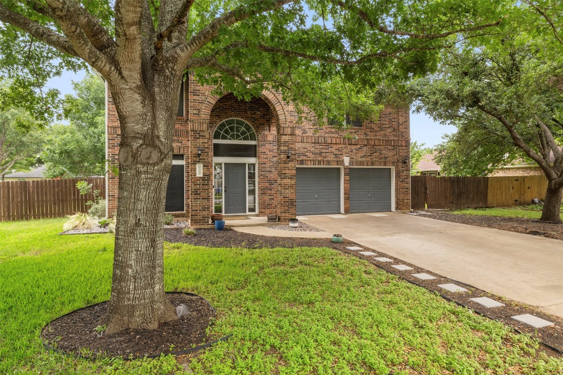 a front view of a house with yard and green space