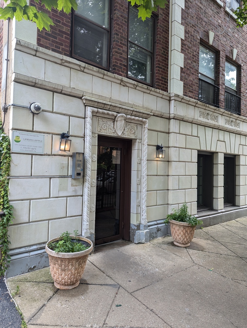 a front view of a house with a yard and potted plants