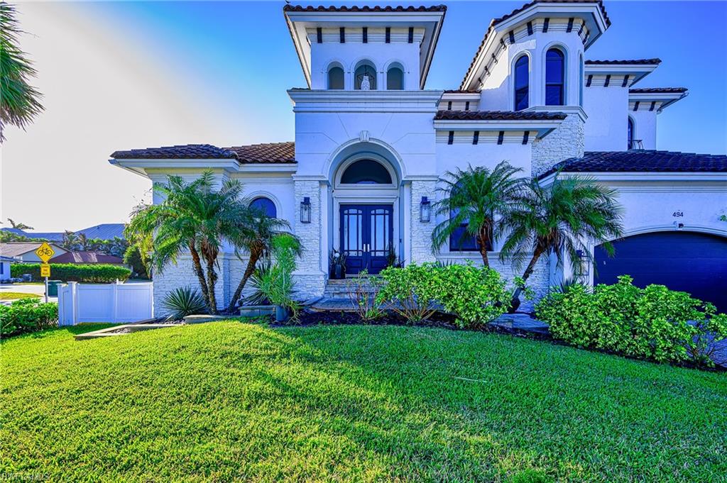 Mediterranean / spanish-style house featuring french doors, a garage, and a front lawn