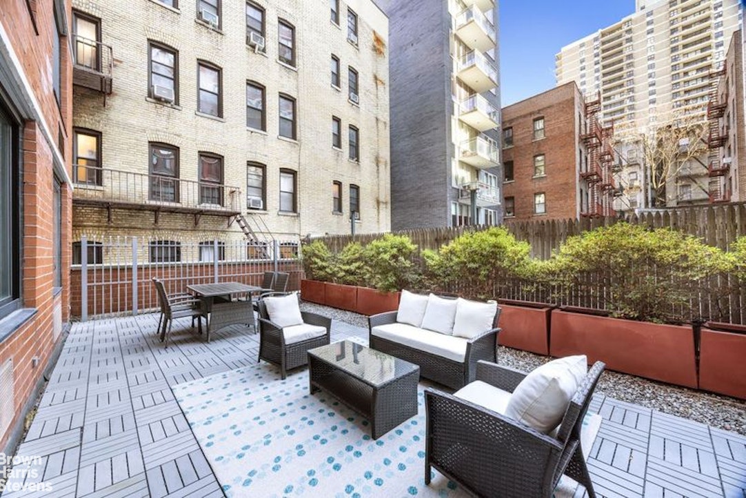 a view of a patio with couches and a potted plant on a table