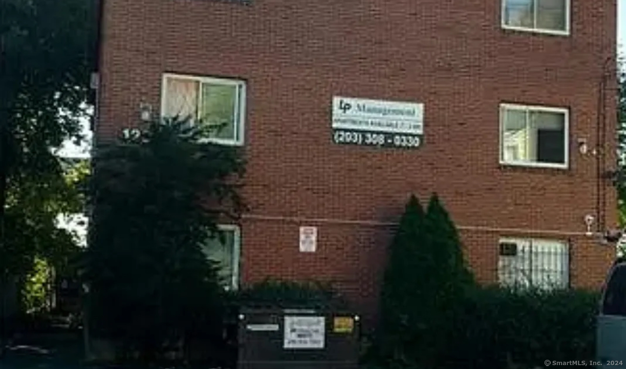 a view of a brick house next to a yard