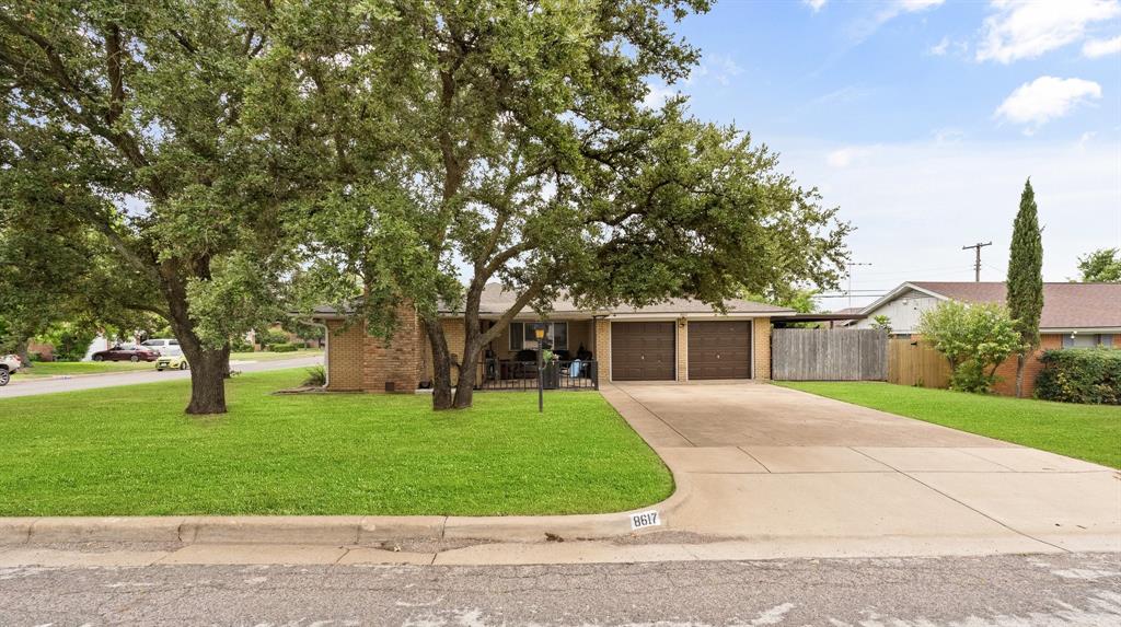 a front view of a house with a yard and trees