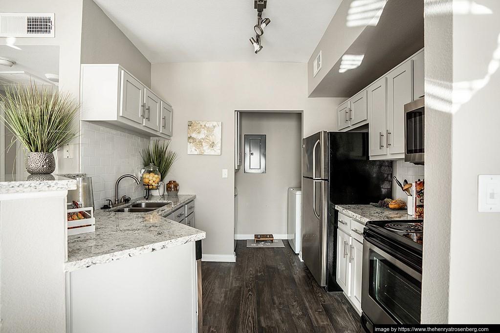 a kitchen with granite countertop a sink stove and refrigerator