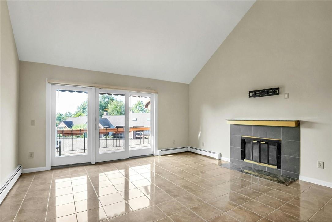 a view of an empty room with a fireplace and a window