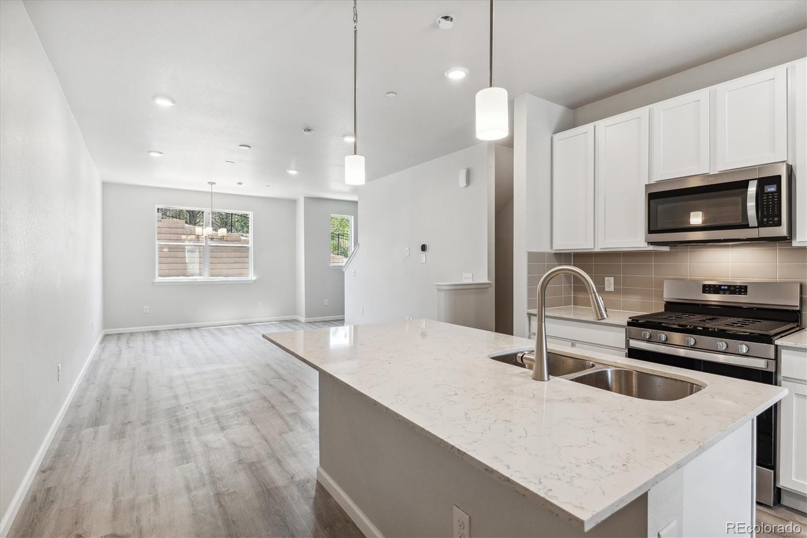 a kitchen with stainless steel appliances granite countertop a stove a sink a microwave and wooden cabinets