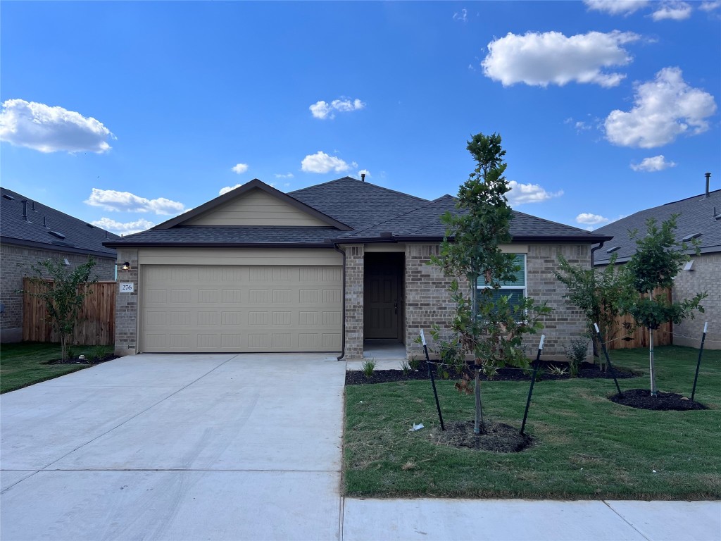 a front view of a house with a yard and a garage