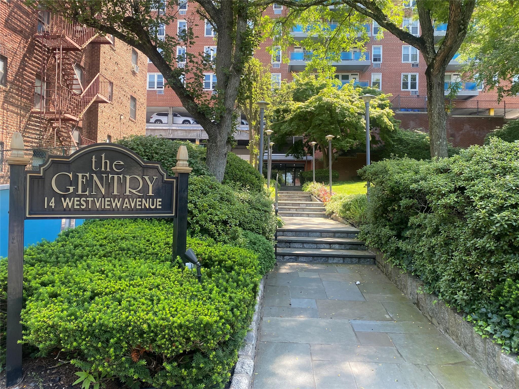 a view of sign board with buildings in the background