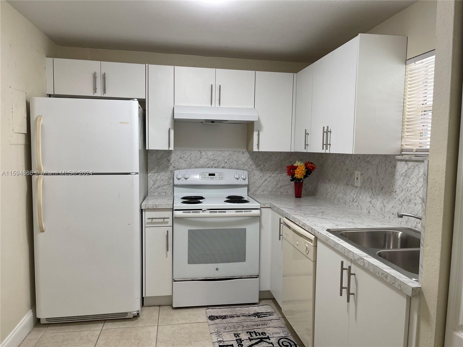 a kitchen with cabinets and white stainless steel appliances