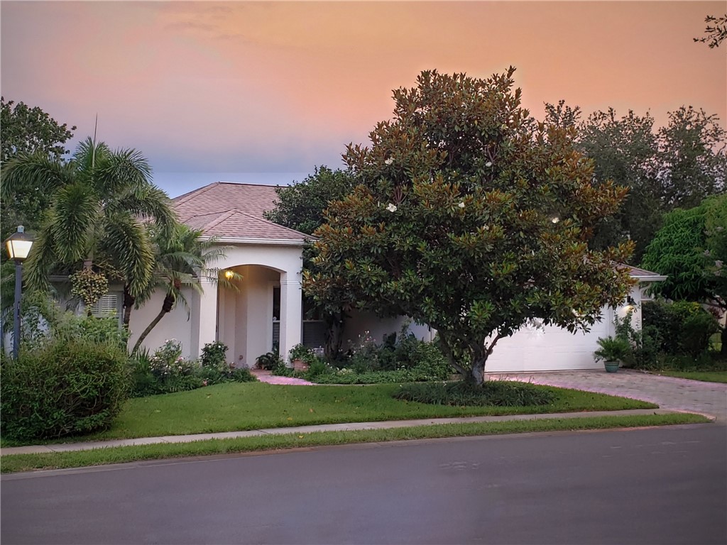 a front view of a house with a yard and trees