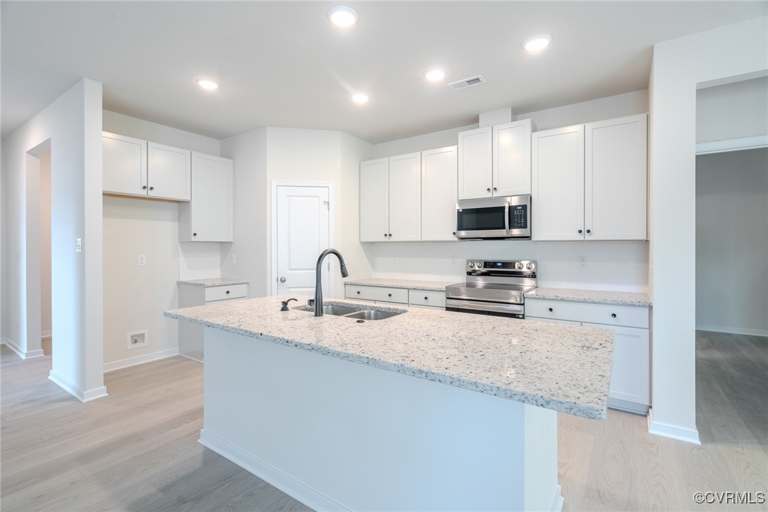 a kitchen with sink a microwave and cabinets