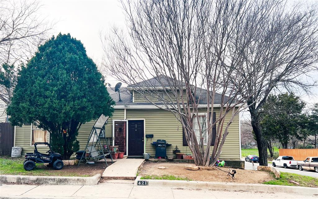 a view of a house with street and trees