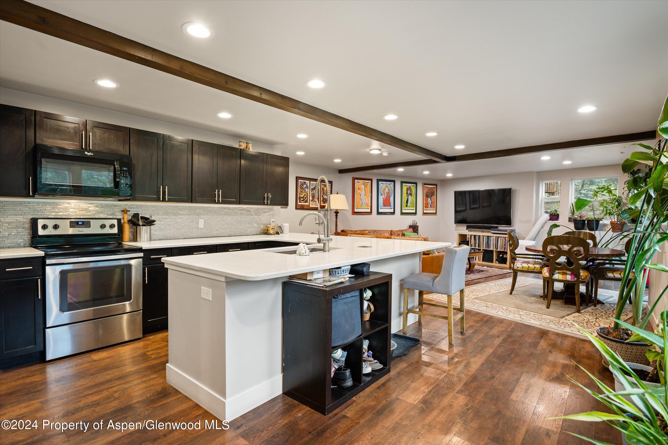 a kitchen with a sink stainless steel appliances and view living room