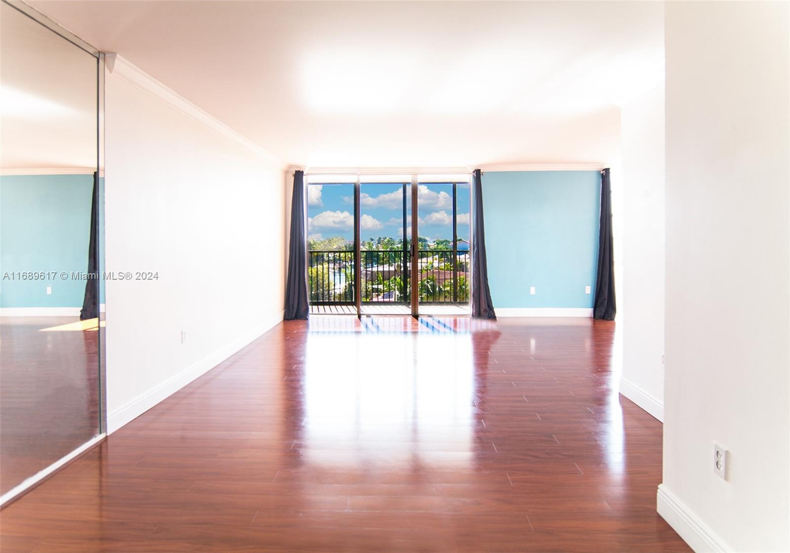 a view of a room with wooden floor and a floor to ceiling window