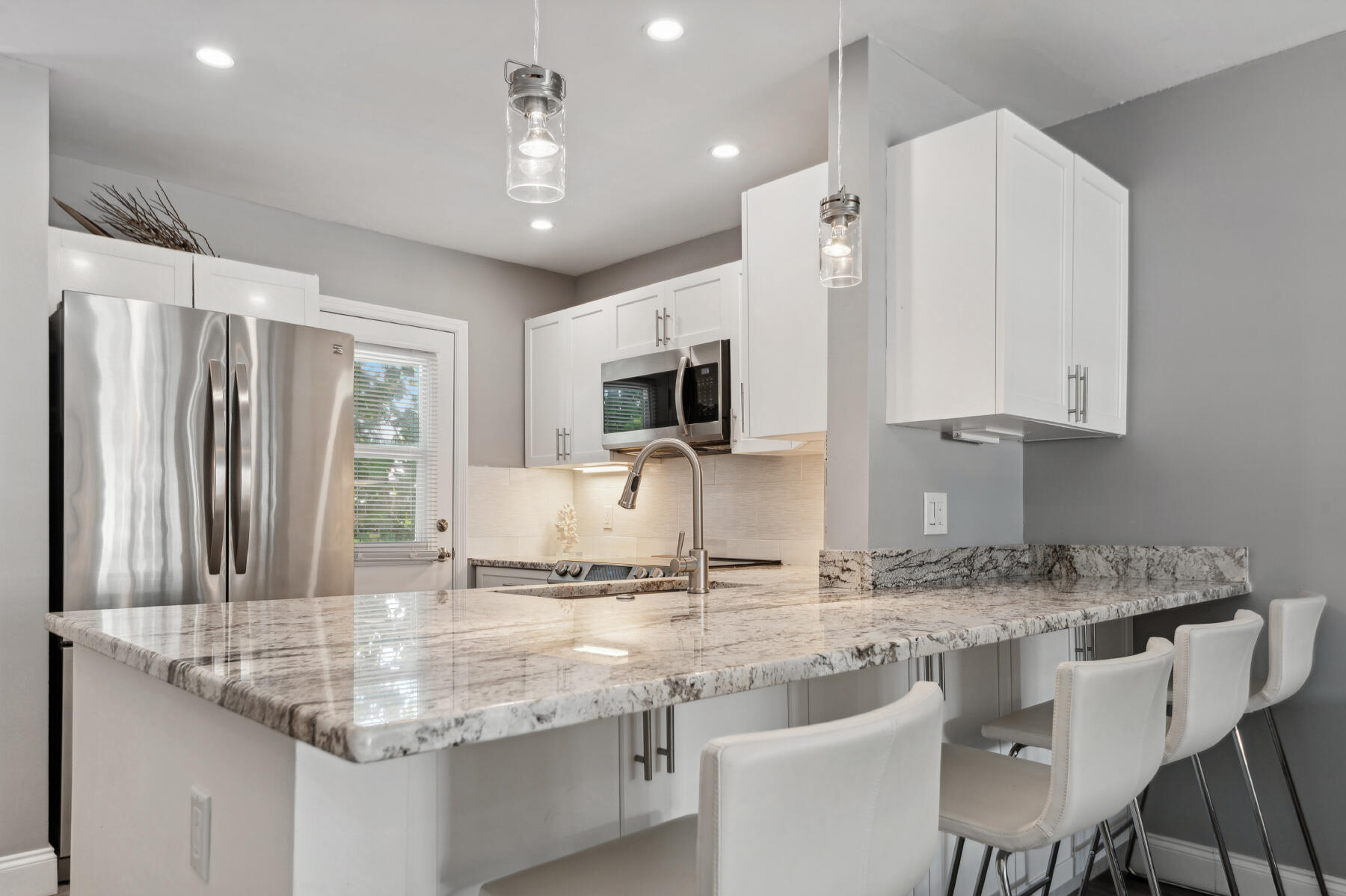 a kitchen with granite countertop a sink and white cabinets