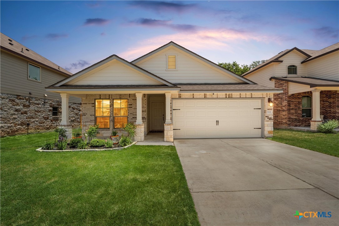 a front view of a house with a yard and garage