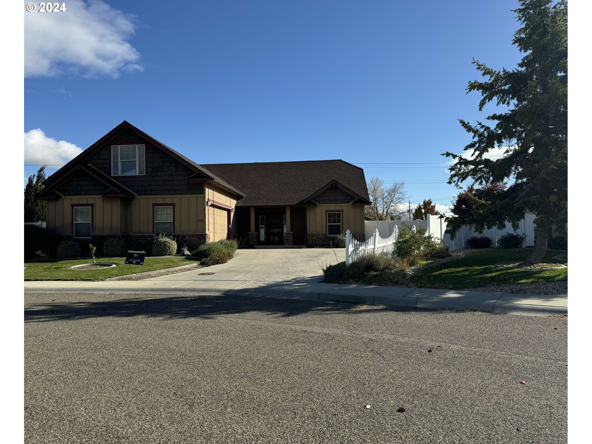 a front view of a house with a garden and yard