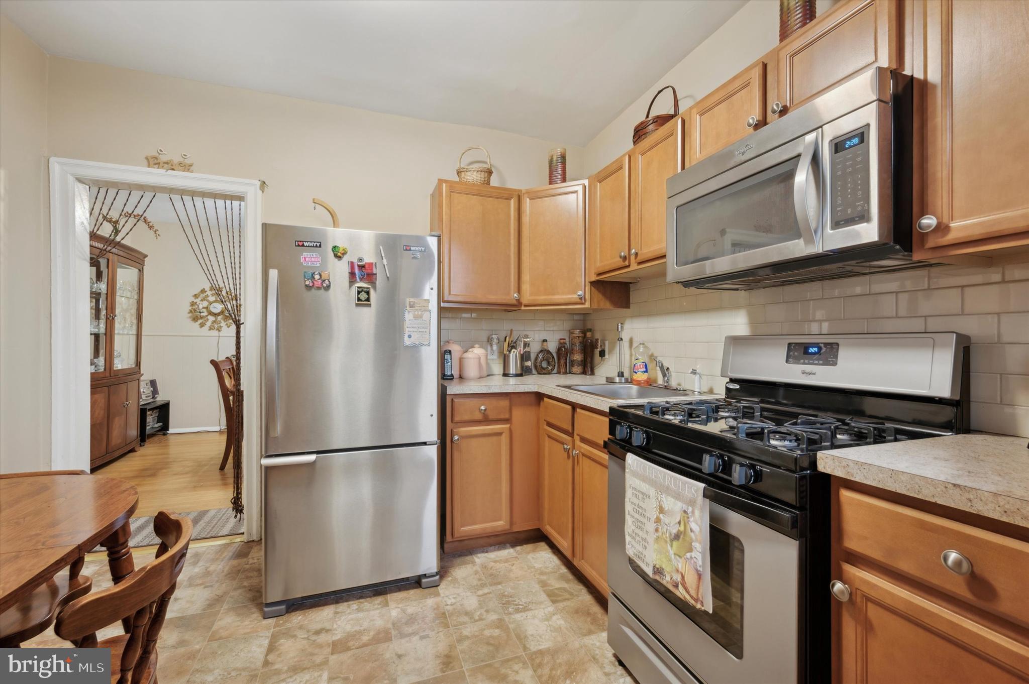 a kitchen with stainless steel appliances granite countertop a refrigerator stove top oven and sink