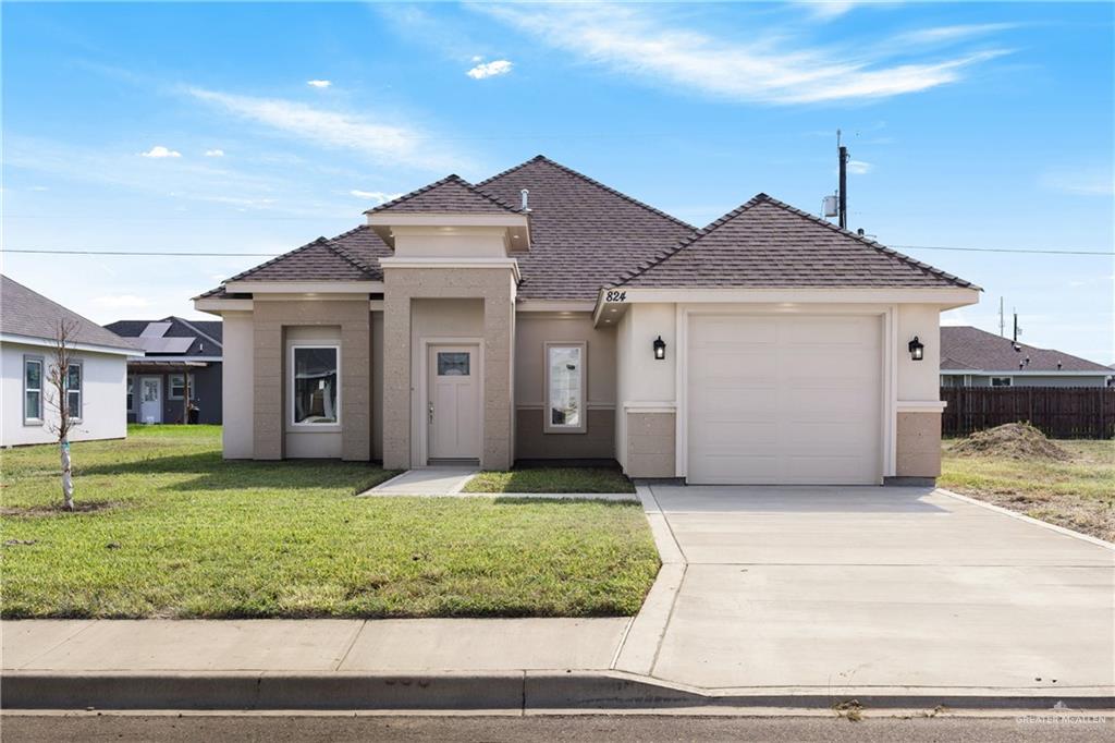 a front view of a house with a yard and garage