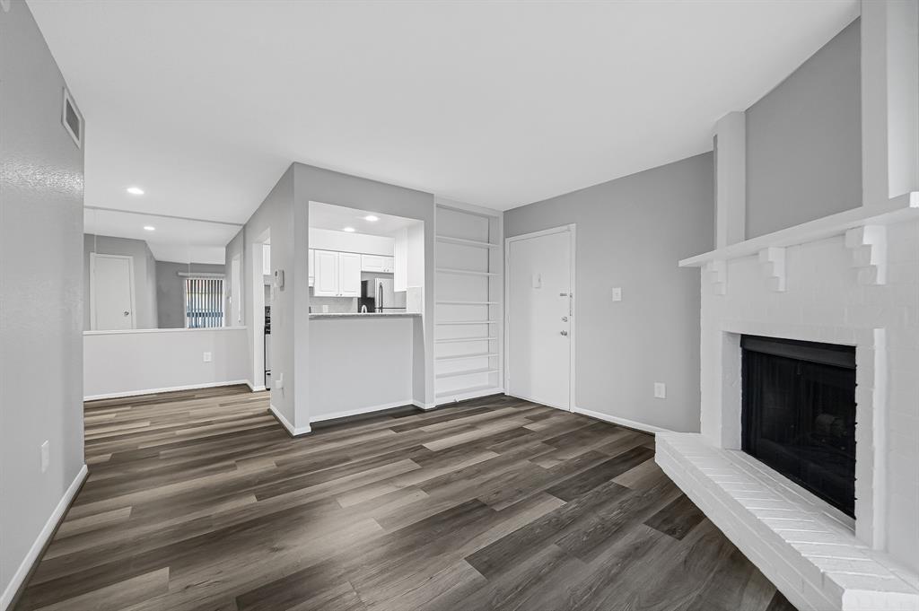 a view of empty room with wooden floor and fireplace